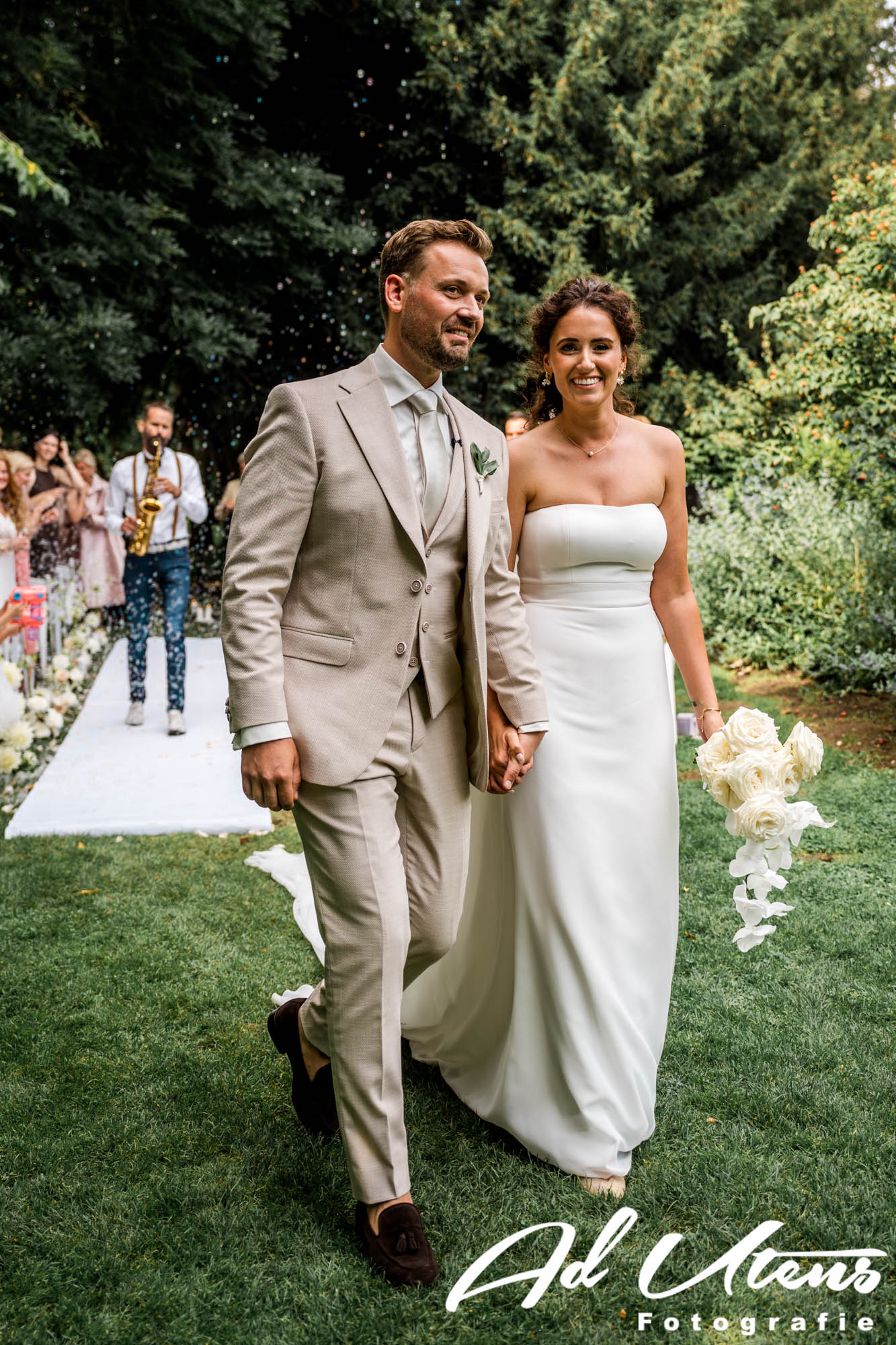 Pieter_Sax-by_Ad-Utens_fotografie - 00005 Bruidspaar verlaat Trouwceremonie Kasteel de Hoogenweerth met Mr. Pieter Sax op de achtergrond - track Jubel