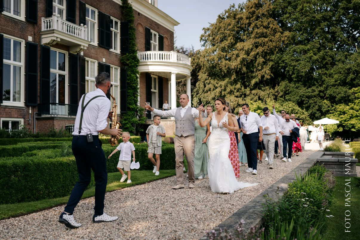 Al spelend op mijn saxofoon begeleid ik het bruidspaar van de Trouwborrel naar Bruiloft Diner Al spelend op mijn saxofoon begeleid Pieter het bruidspaar van de Trouwborrel naar Bruiloft Diner bij Rhederoord